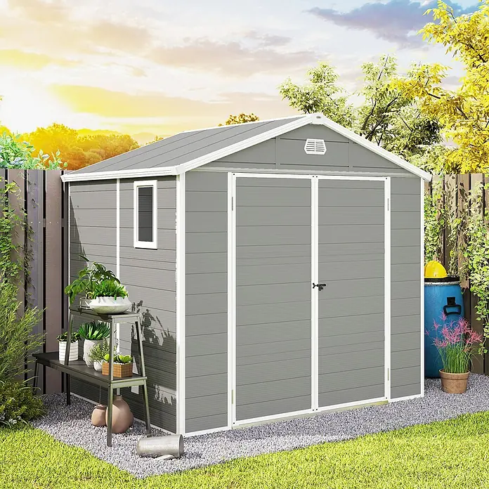 Outsunny Gerätehaus - Außenbreite inkl. Dachüberstand: 240 cm, Außentiefe inkl. Dachüberstand: 190 cm, Aluminium, Hellgrau - Ein grauer Metallgartenschuppen mit weißem Rand, Fenster und Doppeltüren, auf Kies in einem üppigen Garten.