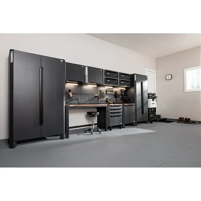 ToughBuilt Armario multiusos metálico - L x An x Al: 47 x 71 x 84 cm, Número de puertas: 2 ud. - Sistema de almacenamiento modular de garaje Toughbuilt gris oscuro con armarios, banco de trabajo y panel perforado para organizar herramientas en un taller.