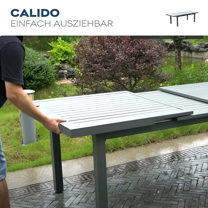 Home Deluxe Gartentisch-Set CALIDO Gartentisch - Gesamtumfang: 1 -tlg., Ausziehbar - Eine Person verlängert einen grauen Latten-Gartentisch auf einer Terrasse.