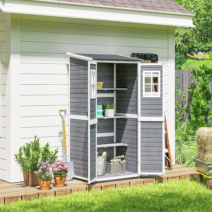 Outsunny Geräteschrank - Außenbreite inkl. Dachüberstand: 91 cm, Außentiefe inkl. Dachüberstand: 69 cm, Holz, Hellgrau - Grauer Holz-Gartenschrank mit offenen Türen und Regalen auf einer Holzterrasse vor einem Haus.