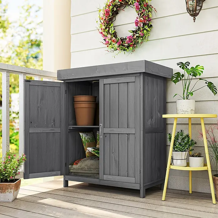 Outsunny Geräteschrank - Außenbreite inkl. Dachüberstand: 74 cm, Außentiefe inkl. Dachüberstand: 43 cm, Holz, Grau - Dunkelgrauer Holz-Außenlagerschrank mit geöffneter Tür, Gartenbedarf auf einer Veranda zeigend.