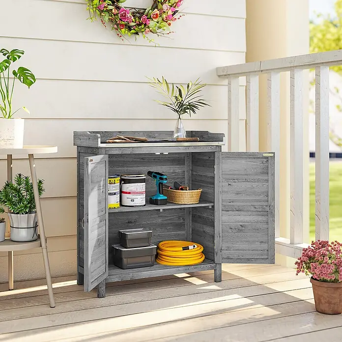Outsunny Geräteschrank - Außenbreite inkl. Dachüberstand: 83 cm, Außentiefe inkl. Dachüberstand: 40 cm, Holz, Grau - Grauer Garten-Aufbewahrungsschrank aus Holz mit geöffneten Türen, der Gartengeräte, Farbdosen und einen Schlauch auf einer Veranda zeigt.