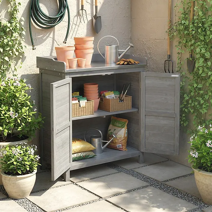 Outsunny Geräteschrank - Außenbreite inkl. Dachüberstand: 83 cm, Außentiefe inkl. Dachüberstand: 40 cm, Holz, Grau - Grauer Garten-Geräteschrank aus Holz mit geöffneten Türen, gefüllt mit Gartentöpfen, Samenpaketen und Werkzeugen.