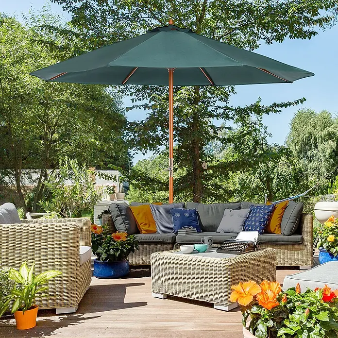 Outsunny Marktschirm rund - Grün, Durchmesser Bespannung: 270 cm - Ein grüner Sonnenschirm mit Holzstange spendet Schatten über einer bequemen Rattan-Sitzgruppe auf einer Holzterrasse.