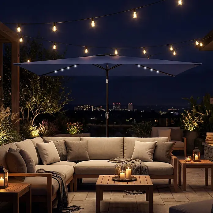 Outsunny Balkonschirm - Marineblau - L-förmiges Outdoor-Sofa und Holztische auf einer Terrasse bei Nacht, beleuchtet von Lichterketten und einem Sonnenschirm mit integrierten LEDs.