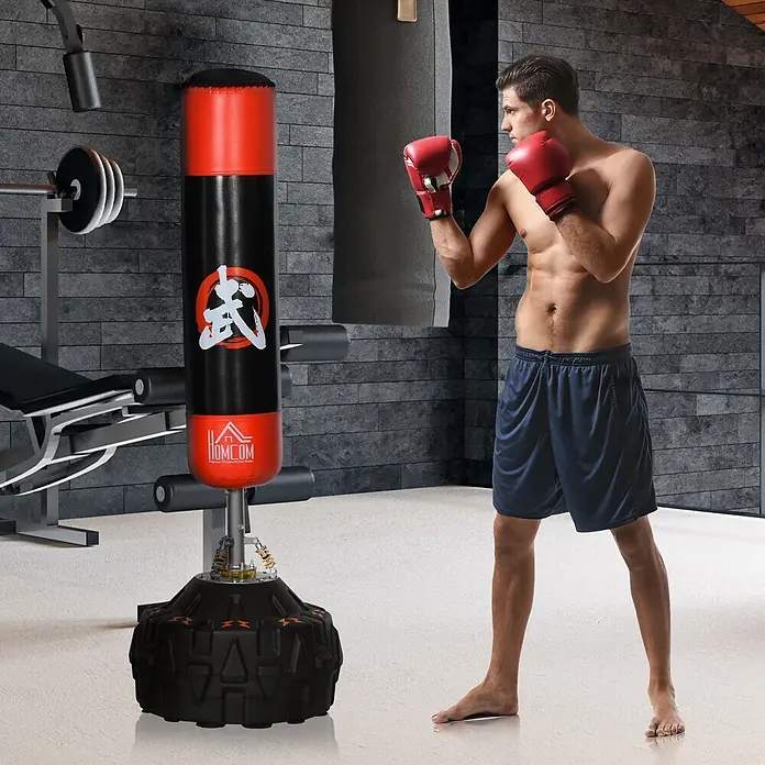 Homcom Boxsack - Schwarz - Mann in Boxhandschuhen trainiert mit einem schwarzen und roten freistehenden Boxsack mit stabiler Basis im Fitnessstudio.
