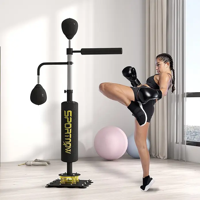 Sportnow Boxsack - Schwarz - Eine Frau trainiert Kampfsport neben einem schwarz-gelben Sportnow Standboxsack mit Speedball und Reflexstange.