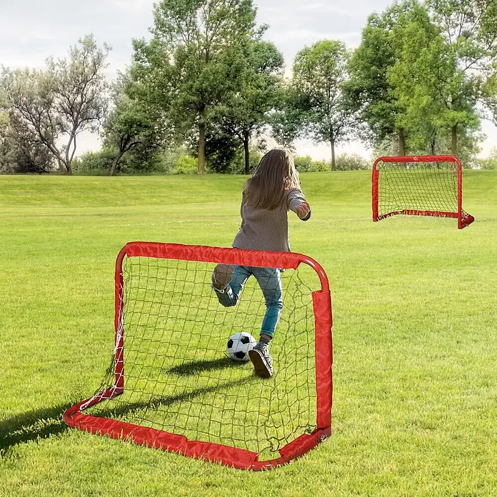 Homcom Fußballtor - Rot, Metall - Zwei rote Mini-Fußballtore auf einem Rasenfeld, ein Kind schießt einen Ball hinein.