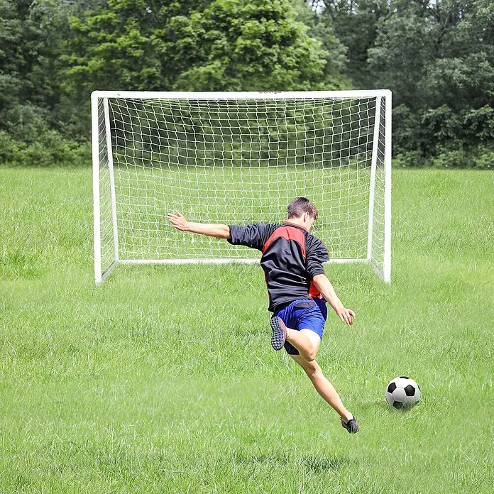 Sportnow Fußballtor - Weiß, Kunststoff - Weißes Fußballtor in Gebrauch, ein Spieler schießt einen Ball.
