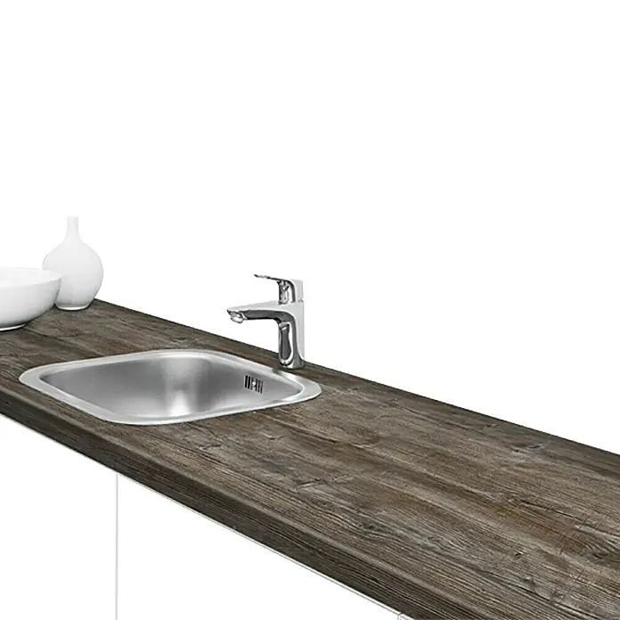 Resopal Premium Küchenarbeitsplatte nach Maß - Mystic Pine, Stärke: 3,8 cm, Breite: 90 cm - Eine Küchenspüle mit Wasserhahn auf einer dunklen Holzoberfläche. Die Spüle ist aus Edelstahl und der Wasserhahn ist aus Chrom.