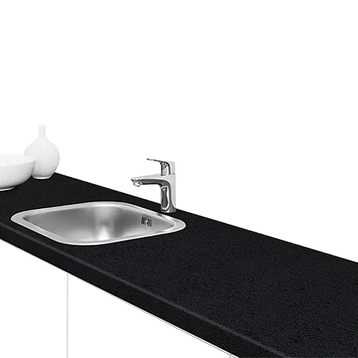 Resopal Premium Encimera de cocina al corte - Black Premium, Espesor: 3,8 cm, Ancho: 60 cm - Un elegante fregadero de cocina con grifo sobre una encimera negra, con un cuenco blanco y un jarrón al lado.