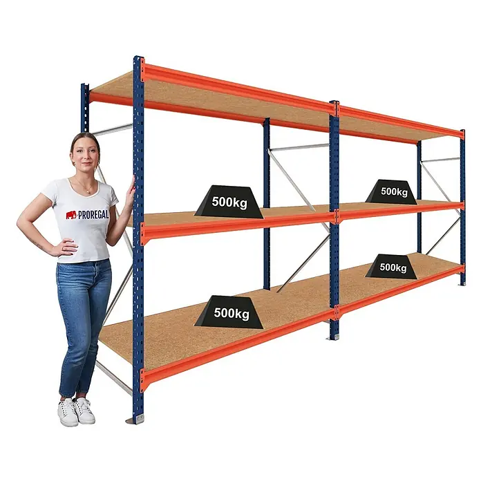 Proregal Schwerlastregal DOMINUS 2er Set mit Spanplatten - Traglast pro Boden: 500 kg, Anzahl Böden: 3 Stk., Stecken, Blau/Orange - Schwerlastregal aus blauem und orangefarbenem Metall mit Holzablagen. Eine Frau steht daneben als Größenvergleich.