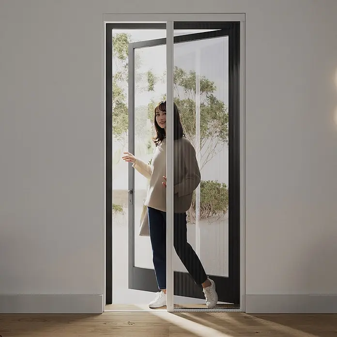 Cocoon Home Concepts Insektenschutz-Türplissee - B x H: 96 x 233 cm, Montage Insektengitter: Schrauben - Ausziehbares Insektenschutzgitter an einer Tür, eine Person tritt hindurch. Weißer Rahmen, dunkles Netz.