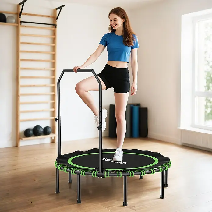 Sportnow Rebounder - 122 x 122 x 129 cm, Schwarz, Grün - Eine Frau steigt für Fitness auf ein schwarz-grünes Minitrampolin mit verstellbarem Haltegriff.