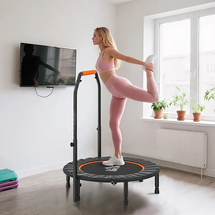 Homcom Rebounder - Stahl, Schwarz - Frau dehnt sich auf einem schwarzen und orangefarbenen Mini-Trampolin mit verstellbarem Griff.