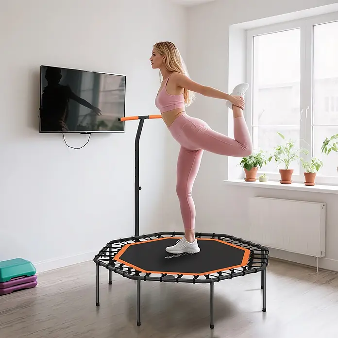 Sportnow Rebounder - Stahl, Schwarz, Orange - Blonde Frau trainiert auf einem schwarz-orangen Minitrampolin mit verstellbarem Griff, führt eine Beinübung aus.