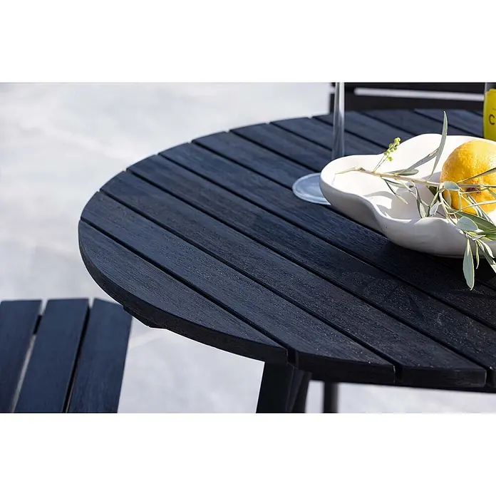Ebuy24 Gartentisch-Set New Mexico - Gesamtumfang: 5 -tlg., L x B x H: 65 x 65 x 95 cm, Ø x H: 65 x 95 cm, Stahl Akazie, Stapelbar - Dunkler, anthrazitfarbener runder Gartentisch mit Latten und Holzoptik-Oberfläche. Eine weiße Schale mit Zitrone und Olivenzweig steht darauf.