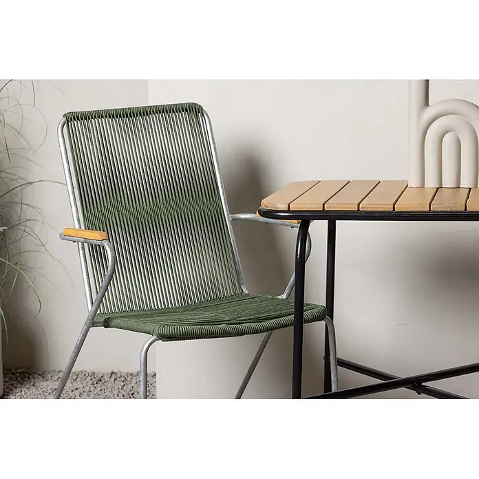 Ebuy24 Gartentisch-Set Holmbeck - Gesamtumfang: 3 -tlg., L x B x H: 70 x 88 x 74 cm, Ø x H: 88 x 74 cm, Stahl Akazie, Stapelbar - Grüner Seilstuhl mit Silberrahmen und Holzlamellentisch mit schwarzem Gestell im Freien.