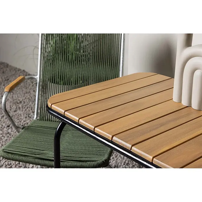Ebuy24 Gartentisch-Set Holmbeck - Gesamtumfang: 3 -tlg., L x B x H: 70 x 88 x 74 cm, Ø x H: 88 x 74 cm, Stahl Akazie, Stapelbar - Ein Holzlattentisch für den Außenbereich mit schwarzem Gestell neben einem grünen Korbstuhl mit Metallrahmen und Holzarmlehnen.