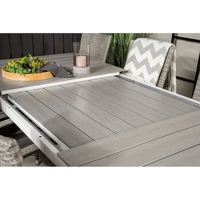 Ebuy24 Gartentisch-Set Levels - Gesamtumfang: 9 -tlg., L x B x H: 100 x 160 x 75 cm, Ø x H: 100 x 75 cm, Rattan, Stahl Aintwood, Aluminium, Stapelbar - Grauer Outdoor-Esstisch mit Lamellenplatte und weißem Gestell, teilweise ausgezogen, um den Ausziehmechanismus zu zeigen.