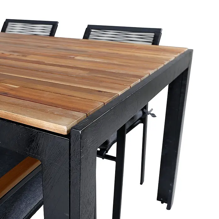 Ebuy24 Gartentisch-Set Bois - Gesamtumfang: 7 -tlg., L x B x H: 205 x 90 x 76 cm, Ø x H: 90 x 76 cm, 100 % Polyester, Holz, Rattan, Stahl Akazie, Aluminium, Stapelbar - Nahaufnahme eines Gartentisches mit Holzlattenplatte und schwarzem Metallrahmen.