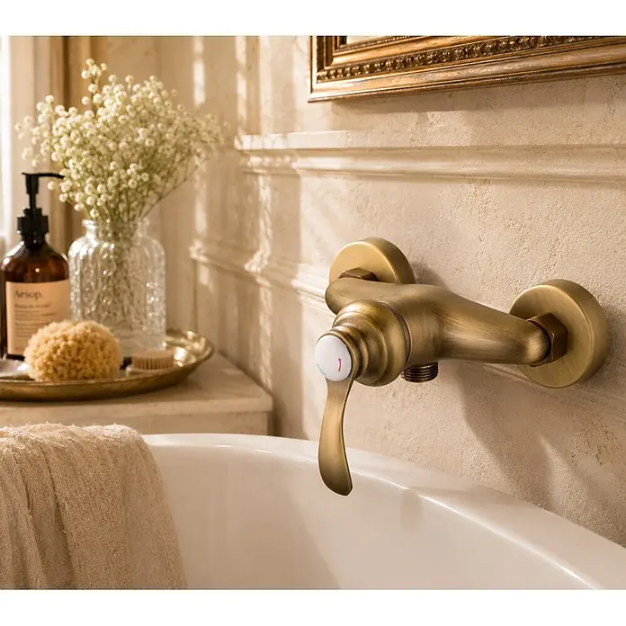 Rousseau Grifo monomando de ducha Byron - Bronce, Satinado - Grifo de baño de latón antiguo montado en pared con mezclador monomando, sobre una bañera blanca.