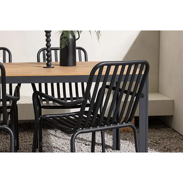 Ebuy24 Gartentisch-Set Break - Gesamtumfang: 5 -tlg., L x B x H: 150 x 90 x 74 cm, Ø x H: 90 x 74 cm, Aintwood Aluminium, Stapelbar - Schwarze Lamellen-Metall-Gartenstühle und ein Esstisch mit Holzplatte auf Kies.