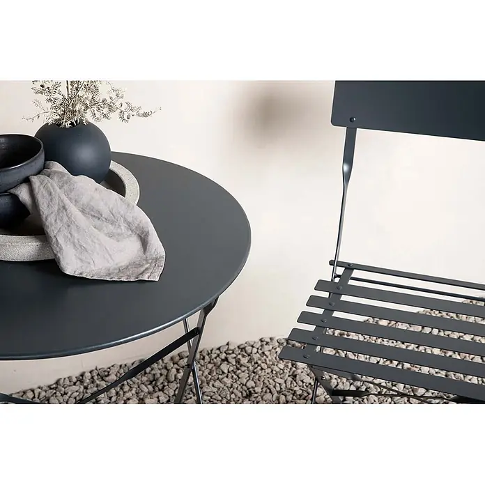 Ebuy24 Gartentisch-Set Marseille - Gesamtumfang: 3 -tlg., L x B x H: 60 x 60 x 71 cm, Ø x H: 60 x 71 cm, Stahl, Stapelbar - Dunkelgrauer Metall-Bistrotisch mit passendem Stuhl auf Kies, dekoriert mit Vase und Schalen.
