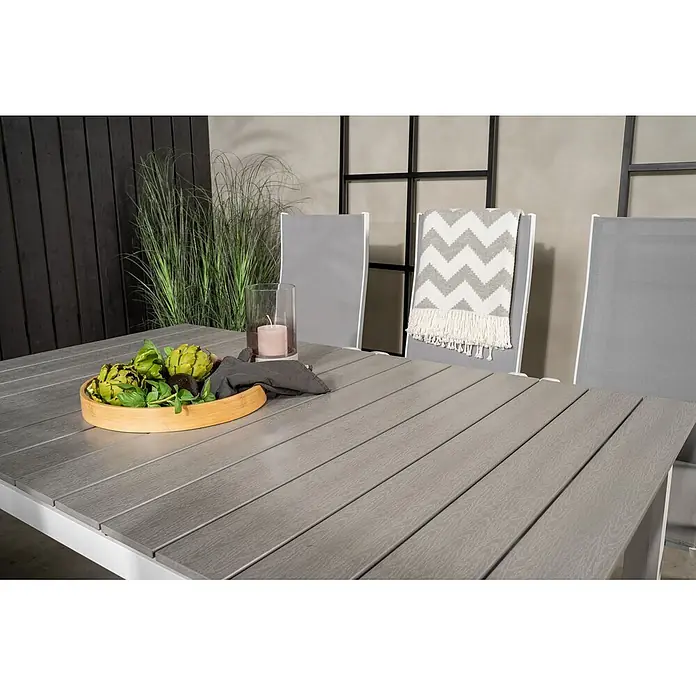 Ebuy24 Gartentisch-Set Levels - Gesamtumfang: 7 -tlg., L x B x H: 100 x 160 x 75 cm, Ø x H: 100 x 75 cm, 30 % Polyester, 70 % PVC, Aluminium, Textil Aintwood, Aluminium, Stapelbar - Grauer Outdoor-Esstisch im Lattenstil, gedeckt für eine Mahlzeit, mit weißem Gestell.