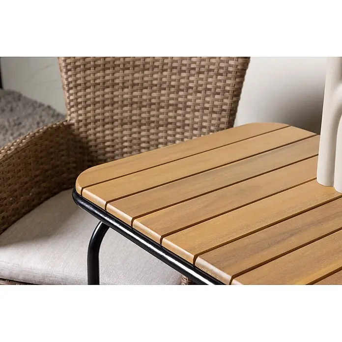 Ebuy24 Gartentisch-Set Holmbeck - Gesamtumfang: 3 -tlg., L x B x H: 70 x 88 x 74 cm, Ø x H: 88 x 74 cm, Aluminium Akazie, Stapelbar - Hellbrauner Lattenholz-Beistelltisch mit schwarzem Metallrahmen, neben einem Korbstuhl platziert.