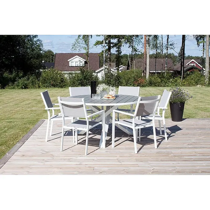 Ebuy24 Gartentisch-Set Parma - Gesamtumfang: 7 -tlg., L x B x H: 140 x 140 x 73 cm, Ø x H: 140 x 73 cm, Aintwood, Stapelbar - Weiß-graue Outdoor-Essgruppe mit rundem Tisch und sechs Stühlen auf einer Holzterrasse.