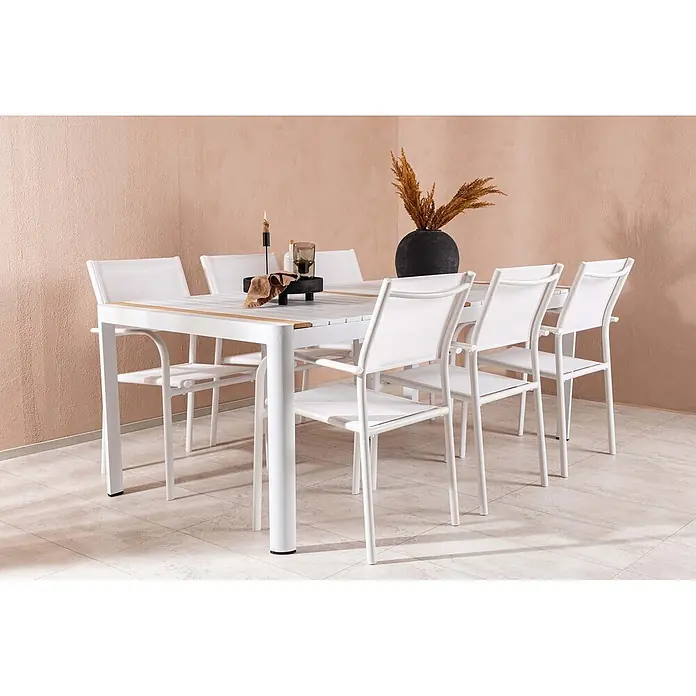 Ebuy24 Gartentisch-Set Togo - Gesamtumfang: 7 -tlg., L x B x H: 100 x 200 x 75 cm, Ø x H: 100 x 75 cm, Aluminium, Stapelbar - Ein weißer Esstisch für den Außenbereich mit Holzdetails und sechs passenden weißen Schlingenstühlen steht auf einer Terrasse.