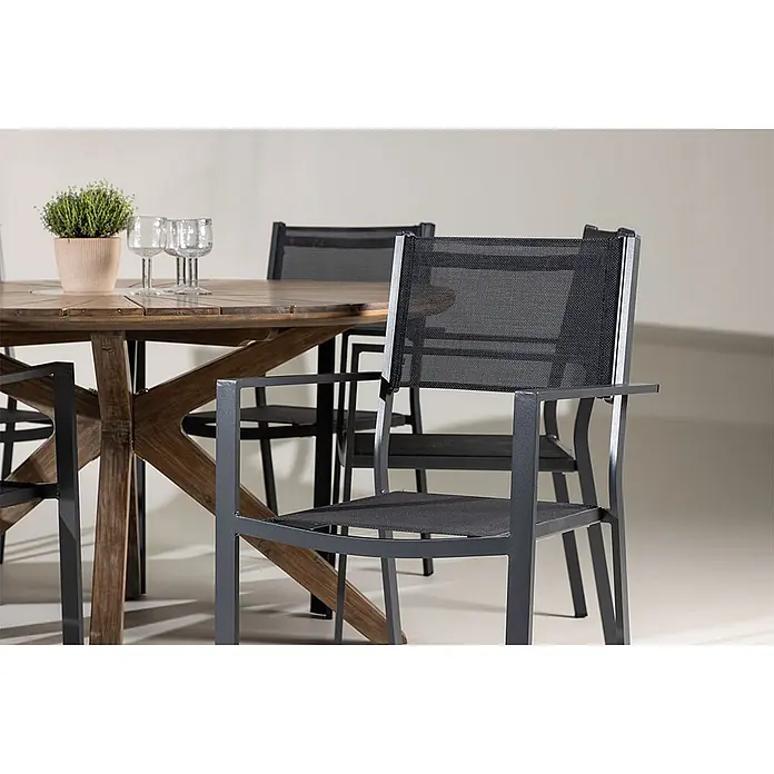 Ebuy24 Gartentisch-Set Rosario - Gesamtumfang: 7 -tlg., Akazie Aluminium Textil, Stapelbar - Runder Holztisch mit schwarzen Netzstühlen für den Außenbereich. Eine Pflanze und zwei Gläser stehen auf dem Tisch.
