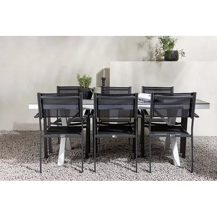 Ebuy24 Gartentisch-Set Garcia - Gesamtumfang: 7 -tlg., L x B x H: 100 x 200 x 74 cm, Ø x H: 100 x 74 cm, Textil Aluminum, Stapelbar - Dunkelgraue Netz-Outdoor-Essgruppe mit grauem Tisch auf Kiesboden.