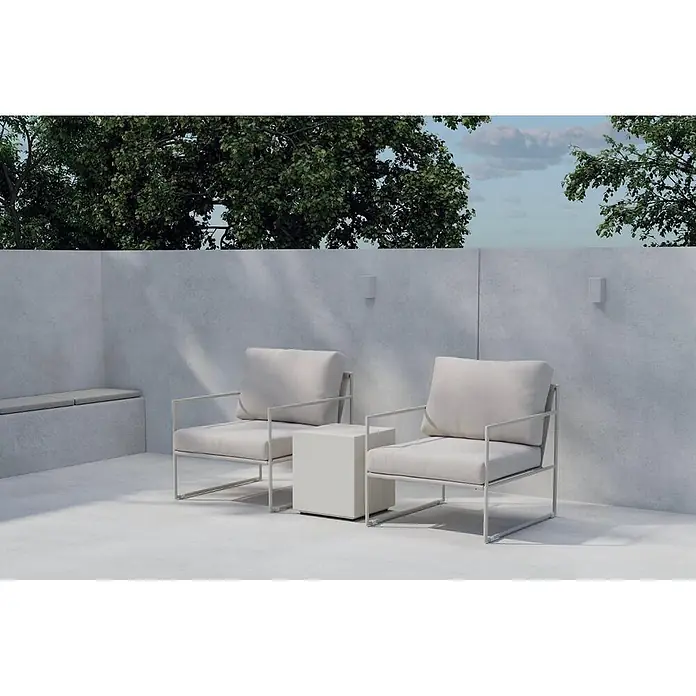 Ebuy24 Loungemöbel-Set Lissabon - 4 -tlg., Aluminium, Beige - Zwei moderne Outdoor-Loungesessel mit hellgrauen Polstern und Gestellen, mit einem passenden Beistelltisch auf einer Terrasse unter Bäumen.