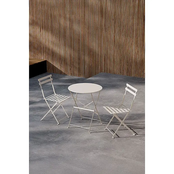 Ebuy24 Loungemöbel-Set Tao - 3 -tlg., Stahl, Beige - Weißes klappbares Metall-Bistro-Set mit rundem Tisch und zwei Stühlen auf einer Terrasse.