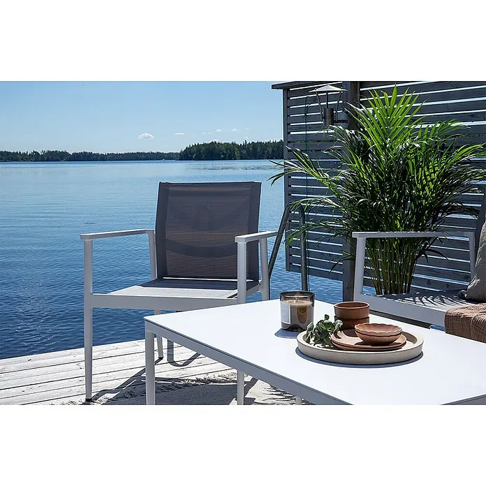 Ebuy24 Loungemöbel-Set Break - 4 -tlg., Aluminium, Weiß - Heller Aluminium-Outdoorstuhl mit dunkelgrauem Netzbezug und passendem Tisch auf einer Seeterrasse.