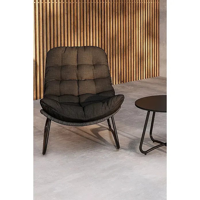 Ebuy24 Loungemöbel-Set Cala - 3 -tlg., Stahl, Anthrazit - Bequemer dunkelgrauer Loungesessel mit schwarzen Metallbeinen, neben einem kleinen schwarzen runden Beistelltisch in einem modernen Raum.