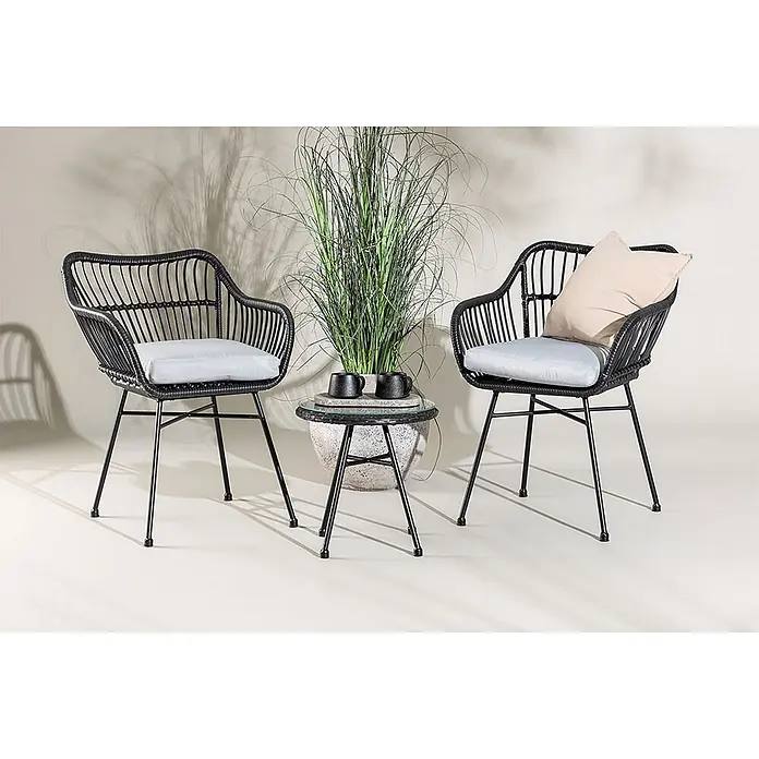Ebuy24 Loungemöbel-Set Viga - 3 -tlg., Korbmöbel, Schwarz - Zwei schwarze Outdoor-Korbsessel mit hellen Kissen und einem runden Beistelltisch mit Pflanze.