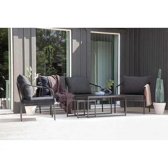 Ebuy24 Loungemöbel-Set Sopot - 4 -tlg., Stahl, Schwarz - Dunkelgraue Outdoor-Lounge-Sitzgruppe mit Sofa, zwei Sesseln und Nesting-Couchtisch auf einer Holzterrasse.