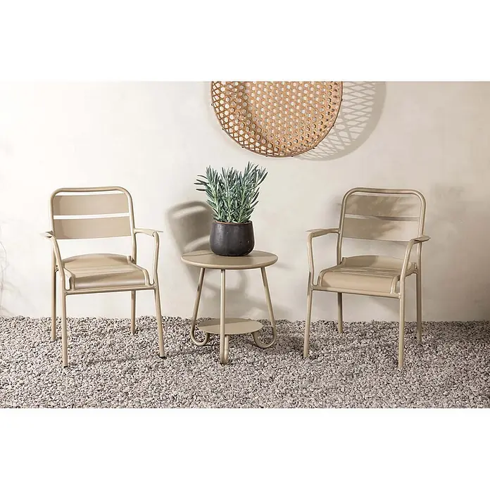 Ebuy24 Loungemöbel-Set Faro - 3 -tlg., Aluminium, Beige - Zwei beigefarbene Metall-Gartenstühle und ein passender runder Tisch mit Pflanze auf Kies.
