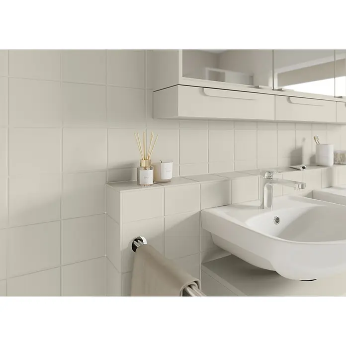 Alpina Buntlack Fliesenlack für Bad & Küche - Braun, Seidenglänzend, 0,75 l, Wasserbasiert - Helle, beige quadratische Keramikfliesen bedecken die Wände eines modernen Badezimmers mit Waschbecken und Chromarmatur.