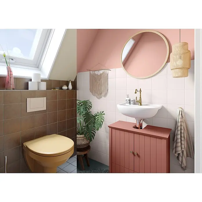 Alpina Buntlack Möbellack für Bad & Küche - Orange, Seidenmatt, 0,75 l, Lösemittelbasiert - Modernes Badezimmer mit rosa Waschtisch, goldener Armatur, rundem Spiegel und senfgelber Toilette. Mit weißen/braunen Fliesen, Dachfenster und großer Pflanze.