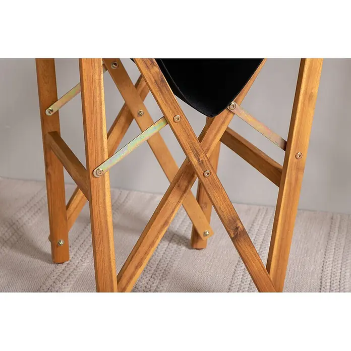Ebuy24 Gartenstuhl Marion 2er-Set - 2 Stk., Polyester, Holz, B x T x H: 53 x 55 x 90 cm - Detailansicht des Untergestells eines hellbraunen Klappstuhls aus Holz mit gekreuzten Beinen, Metallscharnieren und schwarzem Stoff.