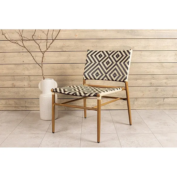 Ebuy24 Gartensessel Calapan - 1 Stk., Aluminum, Rattan, Korbmöbel, Braun, B x T x H: 57 x 69 x 77 cm - Ein Stuhl mit schwarz-cremefarbenem, geometrisch gewebtem Muster und hellem Holzrahmen, drinnen platziert.