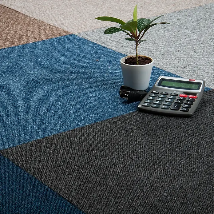 Bricoflor Teppichfliese - Breite: 50 cm, Schlinge, Polypropylen, grau - Geometrische Teppichfliesen in Blau, Grau und Beige, mit Taschenrechner und Pflanze zur Maßstabsangabe.