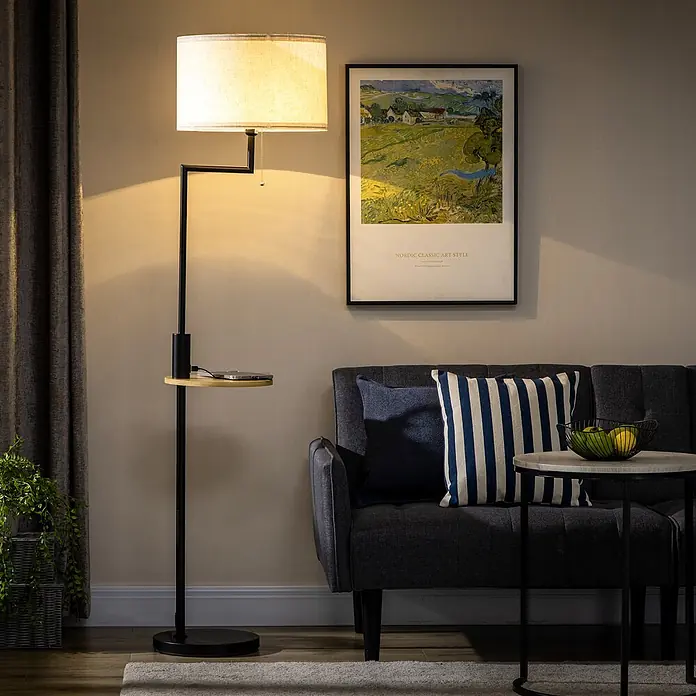 Homcom Stehleuchte - 40 W, Höhe: 170 cm, Schwarz, Weiß, E27 - Stehleuchte aus schwarzem Metall mit beigem Stoffschirm und Beistelltisch aus Holz, neben einem dunkelgrauen Sofa.