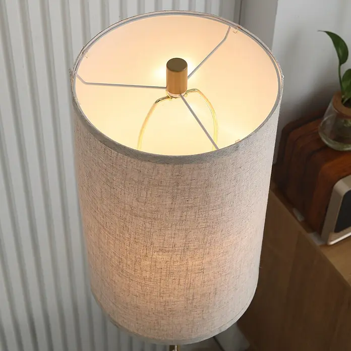Homcom Stehleuchte - 40 W, Höhe: 157 cm, Gold, Cremeweiß, E27 - Oberansicht einer beleuchteten Stehlampe mit hellbeigem Leinen-Lampenschirm, goldener Kappe und Innenrahmen. Pflanze im Hintergrund.