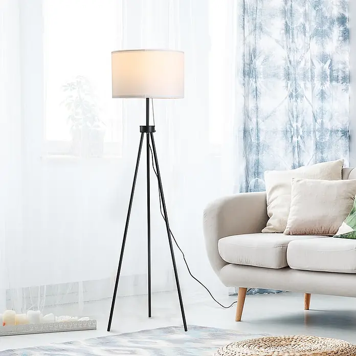 Homcom Stehleuchte - 40 W, Höhe: 152 cm, Schwarz, Weiß, E27 - Schwarze Metall-Dreibein-Stehlampe mit weißem Stoffschirm, beleuchtet ein modernes Wohnzimmer.
