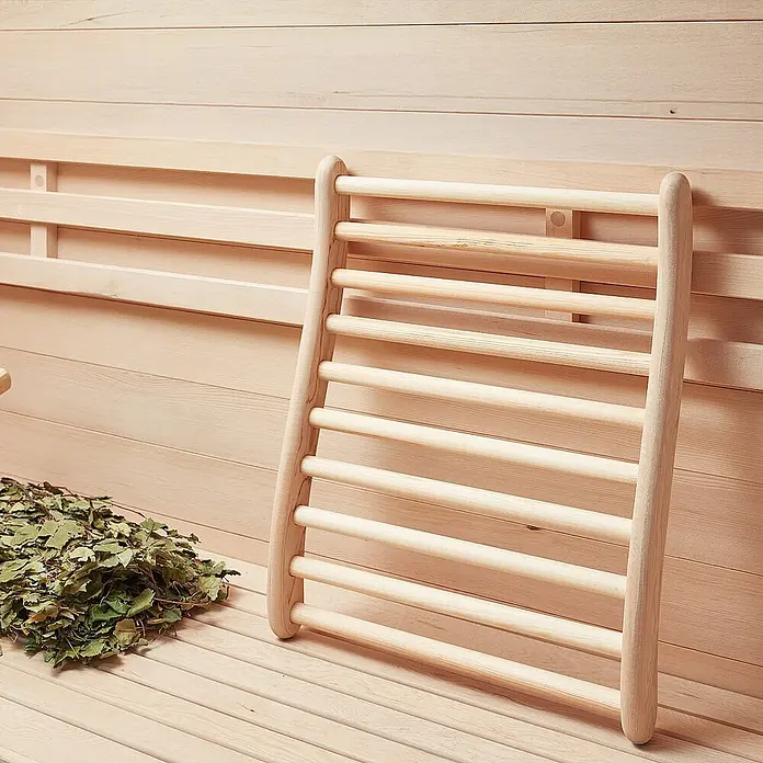 Home Deluxe Elementsauna SKYLINE XL - Elektroofen, Steuerung Ofen: Integriert - Helle Holz-Saunarückenlehne mit Latten, auf einer Bank in einer Naturholzsauna.